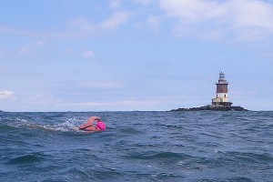Elizabeth Fry swims past Romer Shoal Light on the outbound leg of her round-trip Ederle Swim from Manhattan to Sandy Hook, N.J. last June. (Vladimir Brezina photo)