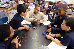 Fourth-graders perform an electromagnetic experiment with the help of their teacher Freddie DeJesus. (Peter Morenus/UConn Photo)