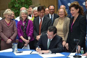 Gov. Dannel P. Malloy during a ceremonial bill signing at the Health Center after a final agreement was reached between the state and Jackson Laboratory. Directly behind the Governor are (left to right) State Rep. Lonnie Reed, DECD Commissioner Catherine Smith, Jackson President Dr. Edison Liu, State Sen. Terry Gerratana, and UConn President Susan Herbst. (Tina Encarnacion/UConn Health Center Photo)