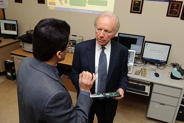 Mohammad Tehranipoor, director of the Center for Security Testing and Reliability, shows Sen. Lieberman an example of a hacked circuit board. (Peter Morenus/UConn Photo)