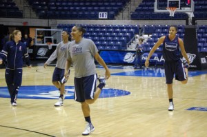 The Huskies begin practice for Sunday's Sweet 16 round at the University of Rhode Island's Ryan Center with stretching and warmups. From left:  Strength and conditioning coach Amanda Kimble, Brianna Banks '15 (CLAS), Kaleena Mosqueda-Lewis '15 (CLAS), and Kiah Stokes '15 (CLAS). (Ken Best/UConn Photo)