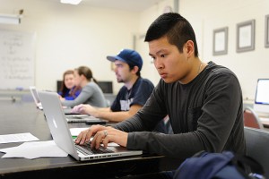 Eric Vo '13 (CLAS) works on his reporting project. (Peter Morenus/UConn Photo)