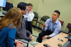 Cigna project manager John Kim, right, speaks with (left to right) Brittany DePoi '13 (ENG), Nhat-Tan Duong '13 (ENG), and Benjamin Luddy '13 (ENG), in the Cigna Innovation Lab. (Ariel Dowski '14 (CLAS)/UConn Photo)
