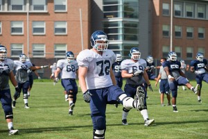 Jimmy Bennett '12 warms up with other members of the UConn football team. (Peter Morenus/UConn Photo)