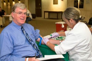 Dr. Richard Everson, himself a cancer researcher, is now also a study participant, as phlebotomist Norah Farris takes a blood draw. (Tina Encarnacion/UConn Health Center Photo) 