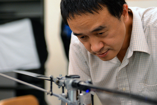 Chengyu Cao, assistant professor of mechanical engineering, with an unmanned vehicle in the lab. (Bret Eckhardt/UConn Photo)