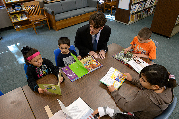 Michael Coyne, professor of educational psychology, reads with a group of first, second and third graders at the Windham Center School (Peter Morenus/UConn Photo)