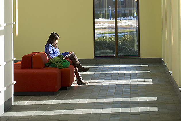 A student sits reading in a hallway in Laurel Hall. The building includes such features as energy-saving window glazing. (Peter Morenus/UConn Photo)