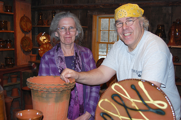 Suzy Staubach, head of General Books at the UConn Co-op, with master potter Guy Wolff in his studio. Wolff's craftsmanship is the topic of a new book by Staubach and an exhibit at Homer Babbidge Library. (Suzanne Zack/UConn Photo)