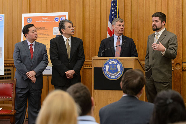 Eric Jackson, right, assistant research professor and director of the Connecticut Transportation Safety Research Center, speaks at the press conference. From left are UConn Provost Mun Choi, Kazem Kazerounian, interim dean of engineering, and James P. Redeker, commissioner of the Connecticut Department of Transportation. (Peter Morenus/UConn Photo)