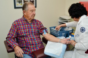 Nurse Mariola Smialek, a research facilitator, prepares a study volunteer for a blood draw. (Tina Encarnacion/UConn Health Center Photo)