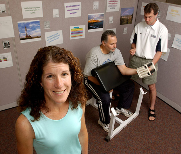 Linda Pescatello, professor of kinesiology, with a test subject and spotter demonstrating a weight training exercise. (File photo)