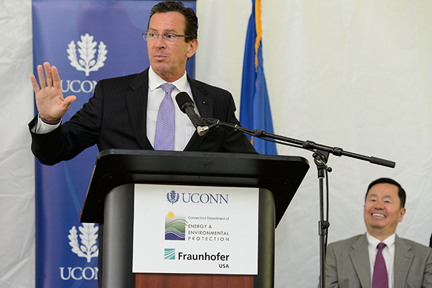 Governor Dannel P. Malloy speaks at an event held at the University of Connecticut Depot Campus to mark the Inauguration of the Fraunhofer Center for Energy Innovation (CEI) at UConn on July 25, 2013. Seated at right is Provost Mun Choi. (Peter Morenus/UConn Photo)