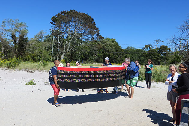 Contestants Aaron Collins, left, director of the Avery Point Student Support Services program, and campus director Mike Alfultis, carry their craft to the beach in preparation for the race. (Noreen Blaschik/UConn Photo)