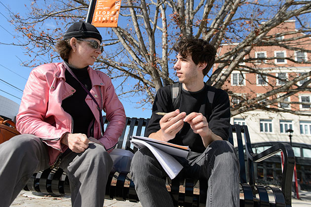 Cora Lynn Deibler, professor of fine art, talks with Bruno Perosino '17 (SFA) about his sketches while seated on a bench at Storrs Center on Oct. 28, 2013. (Peter Morenus/UConn Photo)