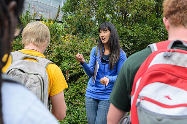 Students observe different trees, shrubs, and vines during a walk around campus with teaching assistant Thao Hau, a graduate student in the College of Agriculture and Natural Resources, as part of Professor Mark Brand's horticulture class on Woody Landscape Plants. (Ariel Dowski '14 (CLAS)/UConn Photo)