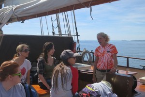 The Mystic Whaler's first mate (in tye-die shirt) addresses the students. (Nathaniel Trumbull/UConn Photo)