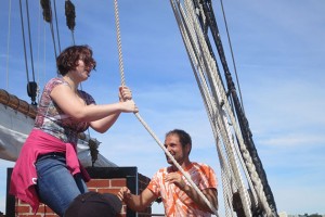 Bonnie Altemus tries her hand at ???, encouraged by a crew member. (Nathaniel Trumbull/UConn Photo)