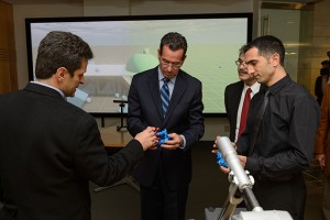 Horea Ilies, associate professor of mechanical engineering, left, Governor Dannel P. Malloy, Kazem Kazerounian, interim dean of engineering and Morad Behandish, a Ph.D. student of mechanical engineering examine objects from a virtual reality demonstration after a ceremony to commemorate the final approval of Next Generation Connecticut legislation held at the Information Technologies Engineering Building on Oct. 21, 2013. (Peter Morenus/UConn Photo)