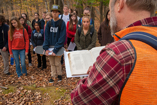 Robert Thorson, professor of geology, reading passages of Thomas Cole and Thoreau to a group of students during a field trip to Tift Pond in the Albert E. Moss Sanctuary. (Sean Flynn/UConn Photo)