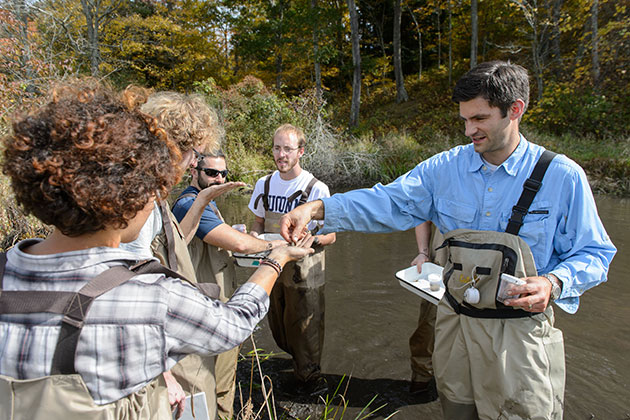 Mark Urban, right, assistant professor of ecology & evolutionary biology leads a limnology class at the Fenton River swamp on Oct. 3, 2013. (Peter Morenus/UConn Photo)
