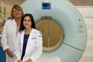 Patti Ardolino and Electra V. Kaloudis, M.D., M.P.H. with the CT scanner used to detect lung cancer in its earliest stages on October 23, 2013. (Tina Encarnacion/UConn Health Center Photo)