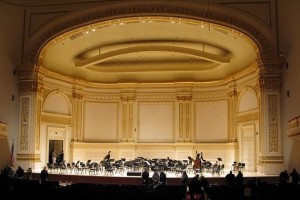 A post-concert photo of the main hall's stage inside of Carnegie Hall. (Photo by Wholtone (Own work) [Public domain], via Wikimedia Commons)