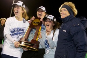 From left, forward Anne Jeute '14 (CLAS), goaltender Sarah Mansfield '14 (CLAS), forward Marie Elena Bolles '14 (NUR), and head coach Nancy Stevens, with the 2013 NCAA Championship trophy. (Keith Lucas for UConn)