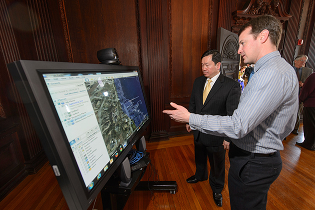 Todd Fake, right, a researcher at the UConn Marine Sciences Technology Center, left, explains a tool for predicting storm surge to Provost Mun Choi during and event to announce the launch of the Institute for Community Resiliency and Climate Adaptation held on Jan. 24, 2014 at the Branford House at the University of Connecticut Avery Point campus in Groton. (Peter Morenus/UConn Photo)