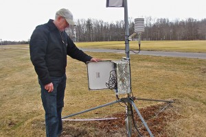 Olsen looks at the weather monitoring device that records temperature every 15 seconds. (Sheila Foran/UConn Photo)