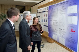 Emily Anstadt explains her poster to Dr. Barry Coller and M.D.-Ph.D. student Alex Adami. (Chris Defrancesco/UConn Health Photo)