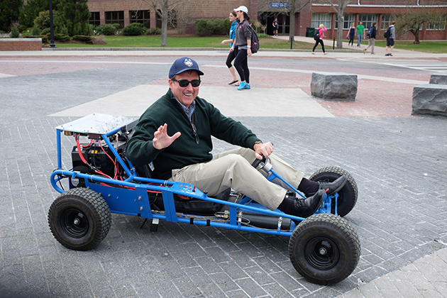 Rich Miller, director of the Office of Environmental Policy, tries out the C2E2 fuel cell-powered go-kart. The Office of Environmental Policy, the Department of Dining Services' Local Routes Program, EcoHusky Student Group, and EcoHouse Learning Community are co-sponsors of the festival held each year on Earth Day. (Peter Morenus/UConn Photo)