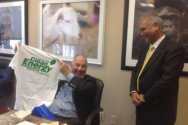 Ed Satell '57 (BUS), left, displays a T-shirt given to him by Prabhakar Singh, director of the Center for Clean Energy Engineering, in the President’s conference room at Gulley Hall, during a recent visit to the Storrs campus. (UConn Foundation Photo)