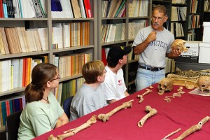 Bellantoni discusses skeletal remains with students at an archaeology field school session.