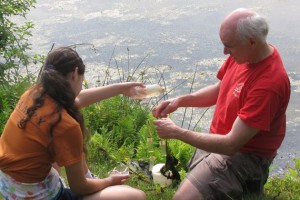 Dr. Kenneth Noll on the shores of Mirror Lake explaining biological collection techniques to KASET participant Hannah Leibowitz, from South Windsor. (Sheila Foran/UConn Photo)
