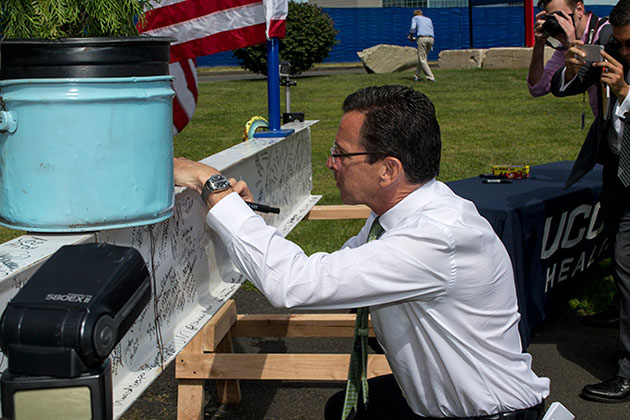 Gov. Dannel P. Malloy signs a steel beam that will become part of the structure, during a topping-out ceremony for the new hospital tower on Sept. 8, 2014. (Tina Encarnacion/UConn Health Photo)