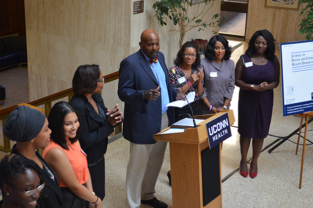 Dr. Cato Laurencin addresses participants in the CICATS Young Innovative Investigator Program during the CICATS Health Disparities Science Cafe on Sept. 17, 2014, in the Academic Lobby at UConn Health. From left, Melissa Carr-Reynolds, Akilah Plair, Sandra Lopez, Dr. Linda Barry, Nilse Dos Santos, La Shondra Ellis, and Trisha Kwarko. (UConn Health Photo)