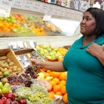 An overweight woman selecting fruits in a grocery store. (Rudd Center on Obesity Research and Policy Photo)