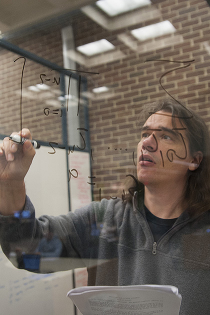 Ralf Schiffler, associate professor of math, ponders an equation. (Sean Flynn/UConn Photo)