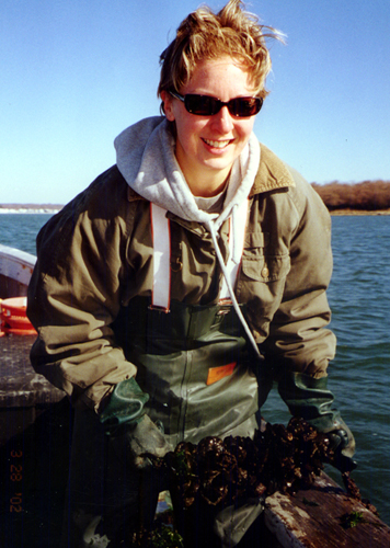 Tessa Getchis inspects blue mussels grown in a collaborative industry research project. (Sea Grant Photo)