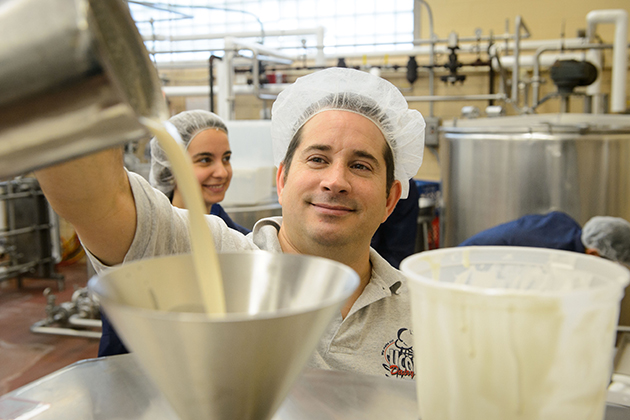 Bill Sciturro, manager of dairy manufacturing in the animal science department, pours a test batch of reduced-sugar ice cream into a batch freezer. (Peter Morenus/UConn Photo)