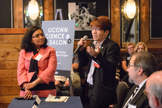 Panelist Anson Ma, center, assistant professor of chemical and biomolecular engineering, makes a presentation about some of his work in the field of 3D printing during the UConn Science Salon held at NIXS Hartford on June 4. At left is Lakshmi Nair, assistant professor of orthopedic surgery and chemical, materials, and biomolecular engineering, who served as moderator. (Peter Morenus/UConn Photo)