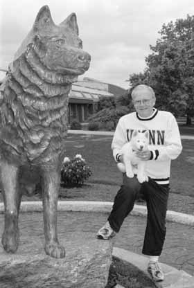 Former President Hartley with Jonathan XI as a puppy next to the bronze Husky statue in 1995.