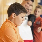 Schoolboys bullying a peer at school.