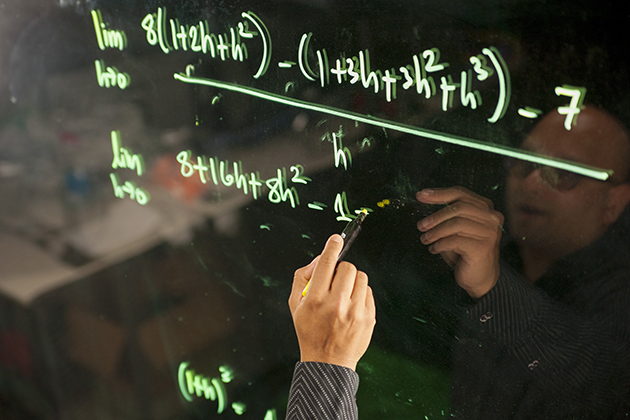 Amit Savkar, assistant professor-in-residence of mathematics, records a lecture using lightboard technology on Sept. 18, 2015. (Sean Flynn/UConn Photo)