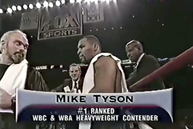 A screen picture of Mike Tyson in the ring with Dr. Cato Laurencin in the background.