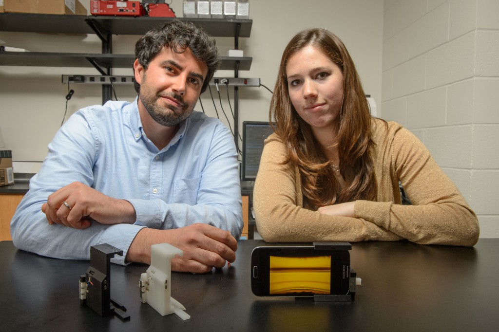 Savas Tasoglu, assistant professor of mechanical engineering, left, and Stephanie Knowlton, a graduate student, with a device to analyze blood for sickle cell disease on Oct. 13, 2015. (Peter Morenus/UConn Photo)