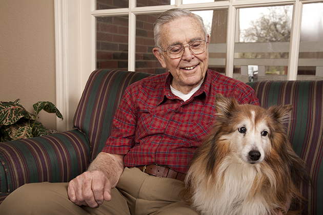 An elderly man at home with his dog. (iStockPhoto)
