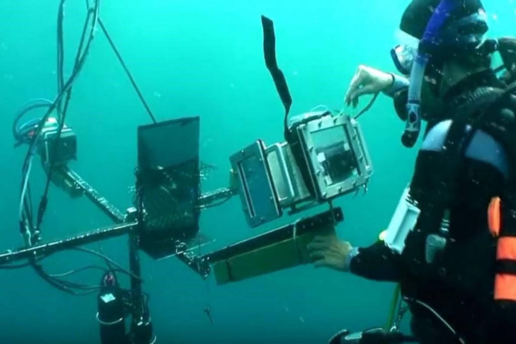 Researcher Parish Brady from the University of Texas at Austin's Department of Integrative Biology uses a video polarimeter to measure polarized light reflected from a live carangid fish placed on a mirrored surface in the clear waters of Curacao. (Jeff Godfrey/UConn Photo)