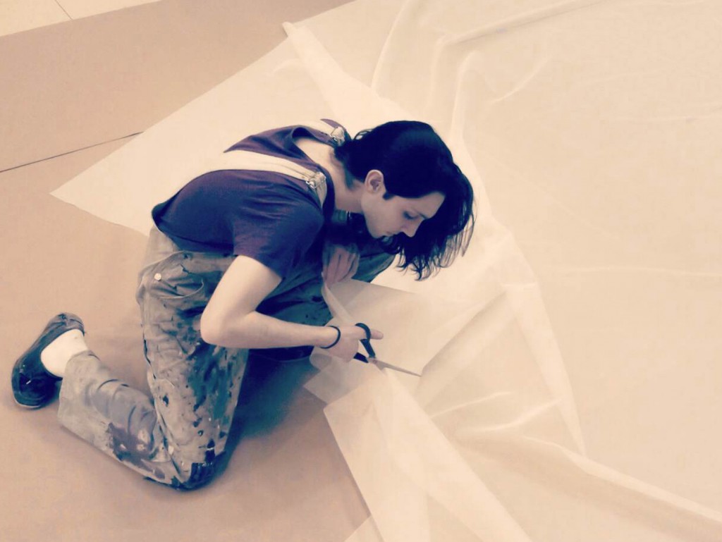 Antonio Campelli '15 cuts fabric while preparing one of his 'larger than life' installations. (Photo courtesy of Antonio Campelli)